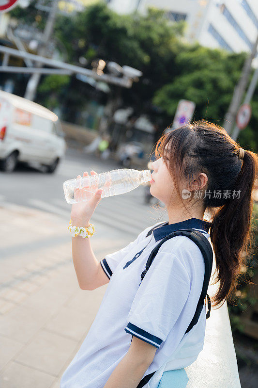 亚洲女孩在阳光下畅饮