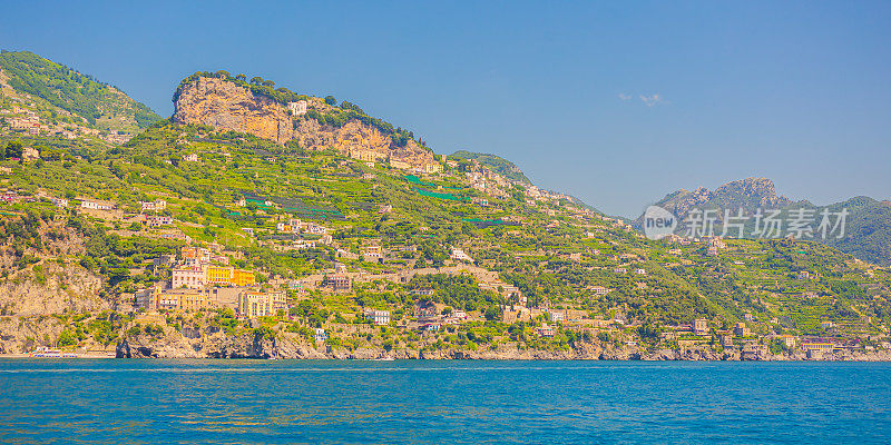 阳光明媚的意大利阿马尔菲海岸。美丽的蓝色第勒尼安海。古老的城市。海滩。山脉。房子在悬崖上。夏天的旅行。意大利的建筑。航行。旅游目的地。