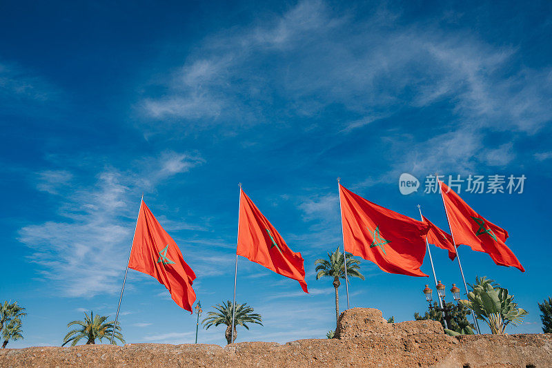 摩洛哥国旗与蓝色的天空上的老城城堡建筑