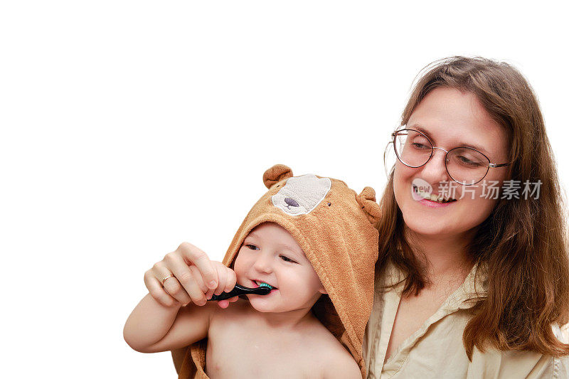 一位母亲和一个快乐的蹒跚学步的婴儿在白色背景上刷牙。妈妈和孩子学着用牙刷刷牙。一岁零三个月的孩子