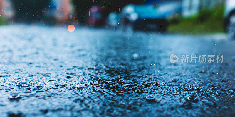 雨滴落在路上。湿沥青。下雨了。天气。水坑。车