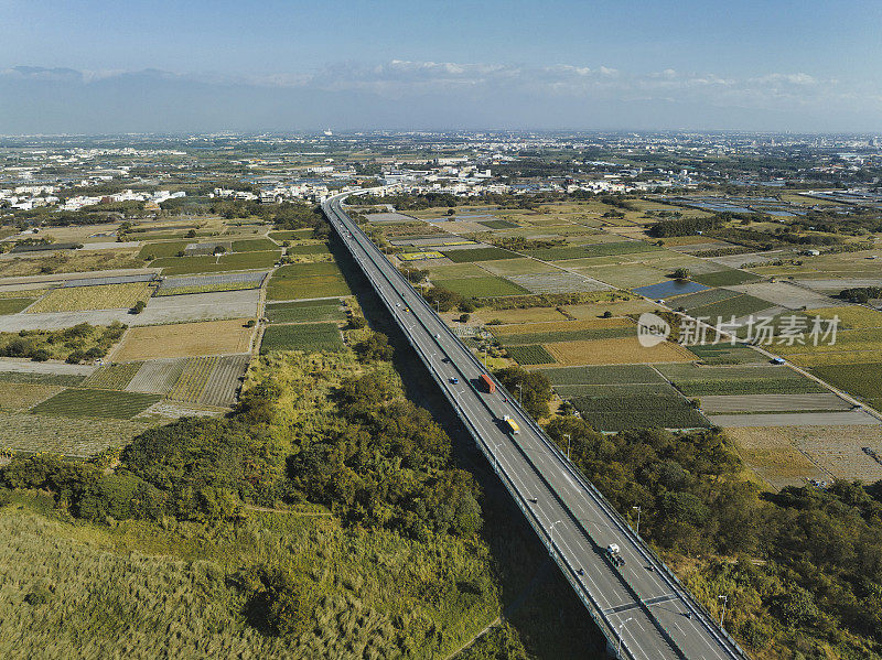 汽车在高速公路路口行驶的鸟瞰图。桥梁道路与绿色花园和树木相连接的建筑概念。