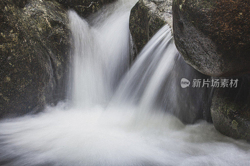 近距离的瀑布流经岩石流入淡水