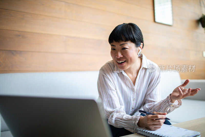 年轻的亚洲女性在家用笔记本电脑工作