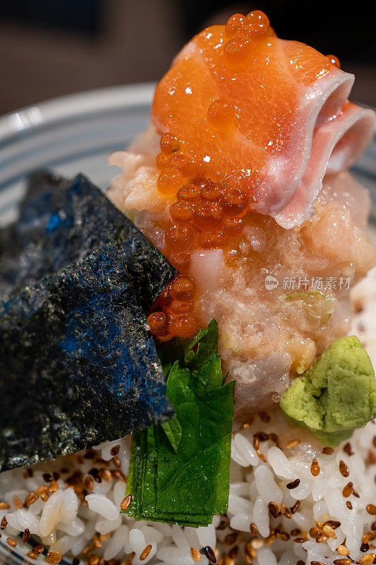 这是一碗著名的日本刺身顿饭的特写镜头，里面装满了鲑鱼和鲑鱼卵。