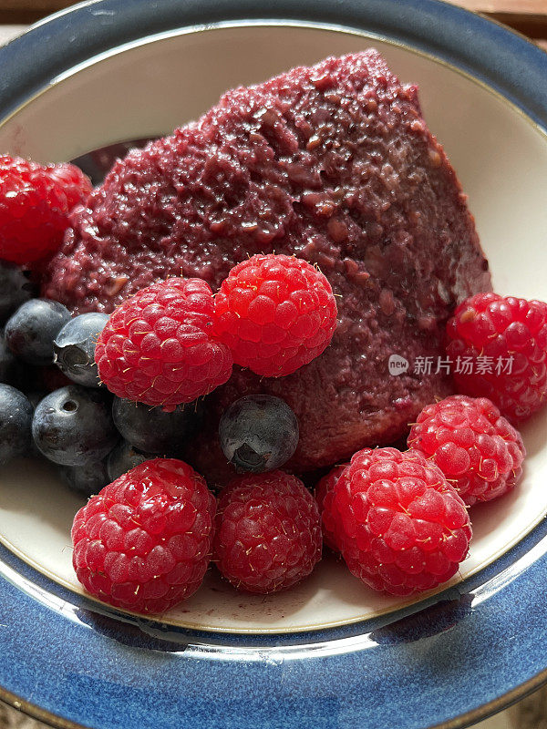 英国自制夏季布丁食谱甜点的特写图像与季节性的夏季水果和浆果，覆盆子和蓝莓，夏季水果布丁制成的白面包片和果汁糖浆，高架视图