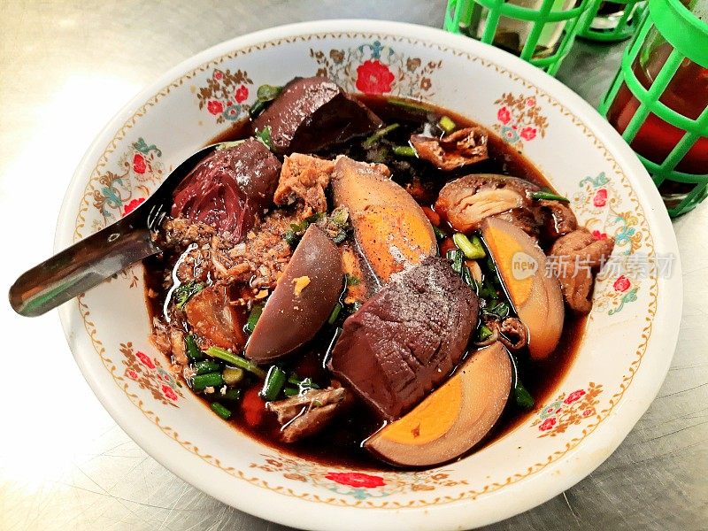 浓汤卷面配香脆五花肉和煮鸡蛋——曼谷街头小吃。