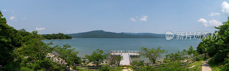 从观景台上，阿坎湖的全景展现无遗。在日本北海道的地平线上，广阔的波光粼粼的水面被郁郁葱葱的风景所衬托。
