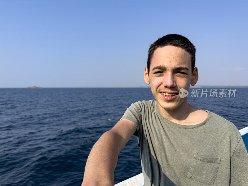 这个男孩正在北爱琴海的一艘男孩游船上旅行。体贴又快乐。晴朗的夏日。旅游的背景。旅游的概念。