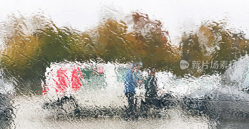 在被雨淋过的停车场里穿行的行人