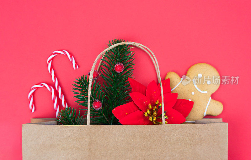 圣诞礼物装在红色背景的环保纸袋里。Flatlay组成。节日礼品购物概念。前视图。特写镜头。