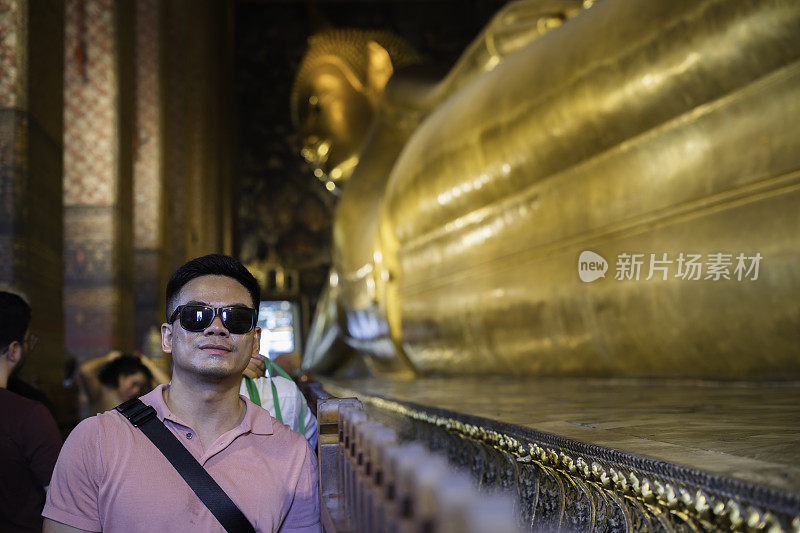 亚洲游客站在泰国曼谷卧佛寺的金卧佛雕像前