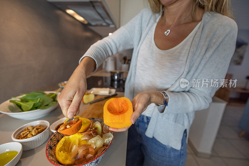 妇女在自家厨房做饭，减少了家里的食物浪费