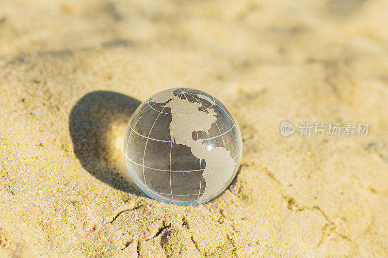 玻璃球躺在沙滩上。地球。可持续性。保护自然概念