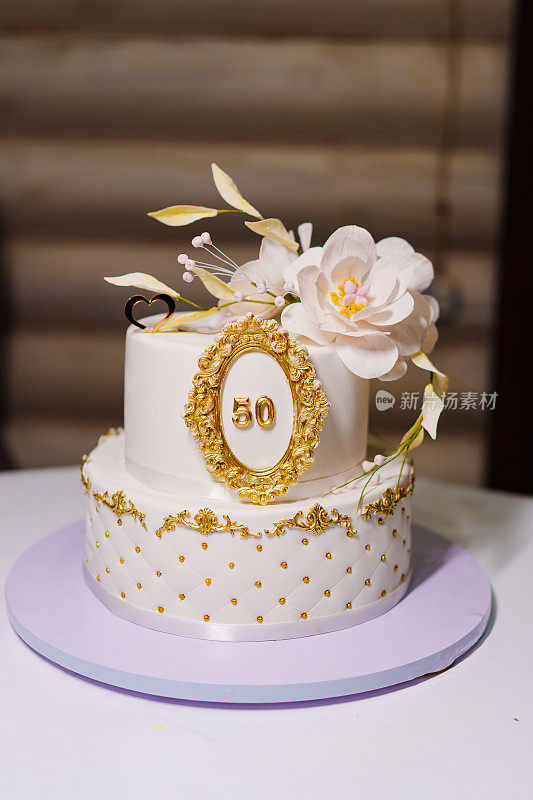美丽的白色双层蛋糕，上面装饰着鲜花。50周年纪念蛋糕。