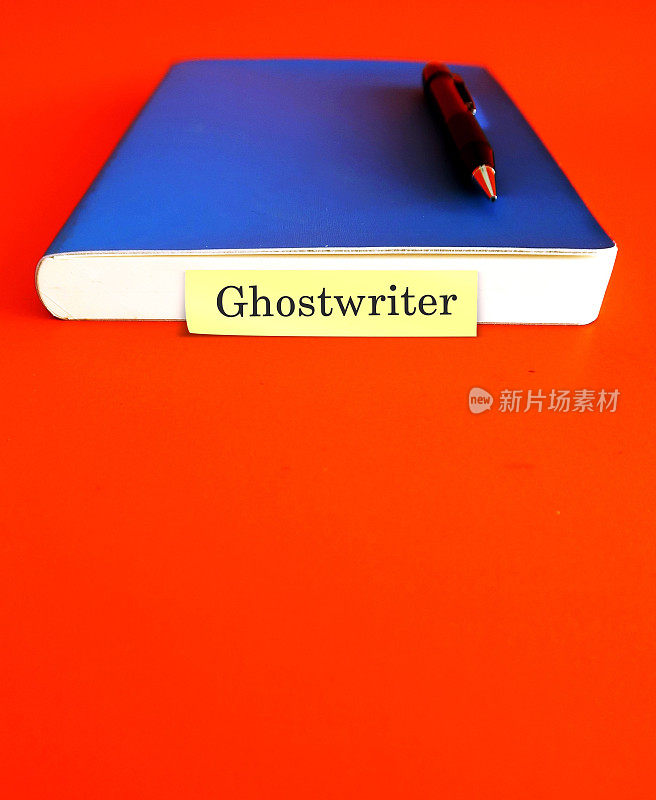 蓝色的笔记本和笔，在复制空间上注明GHOSTWRITER，橙色背景，从代笔中获得更多收入(有才华的作家受雇工作并将其作为作家归功于另一个人)