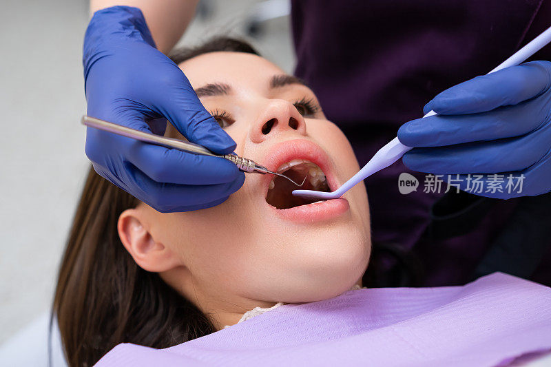 牙医在牙科诊所检查病人的牙齿。