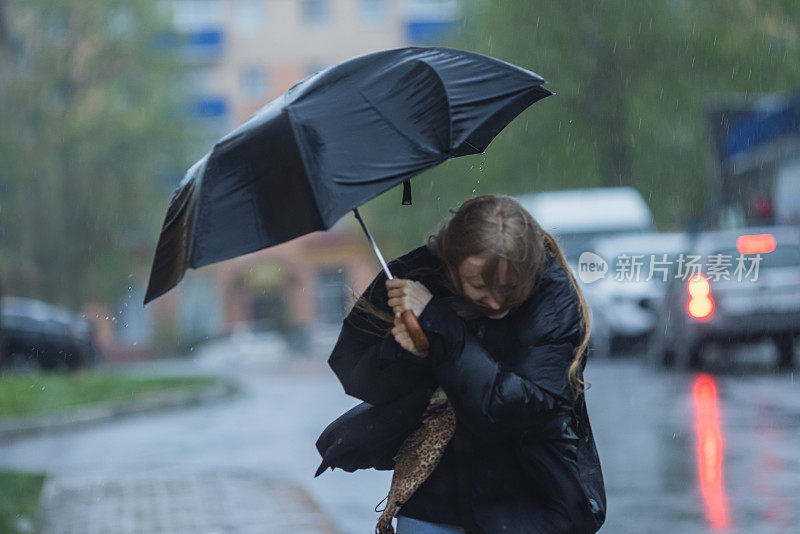 伞下的金发女人。暴风雨天气。暴雨