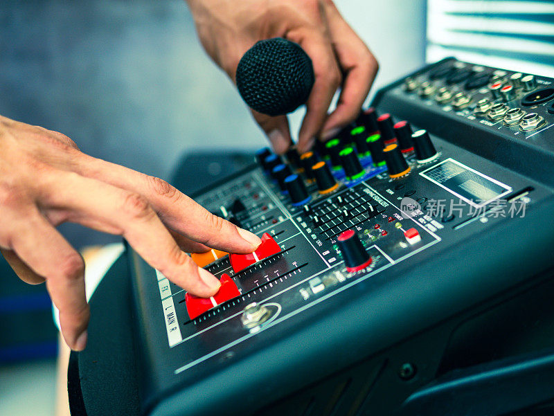 录音师在录音室、广播室、混音室调节混音器的手特写。专业的音频混音控制台，按钮，滑动器和滑块。声音检查。
