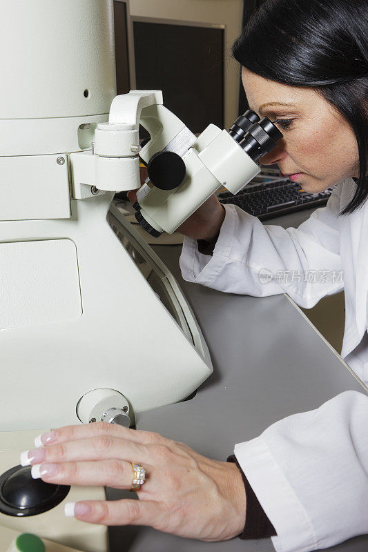 女性科学家使用电子显微镜