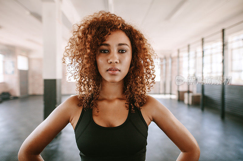 美丽的非洲裔美国女性与卷发在健身房