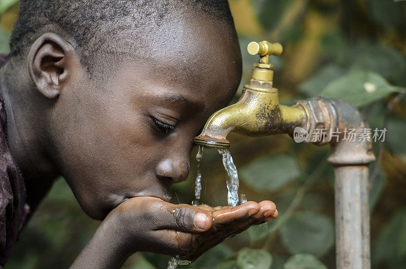 非洲小男孩从水龙头里喝健康干净的水
