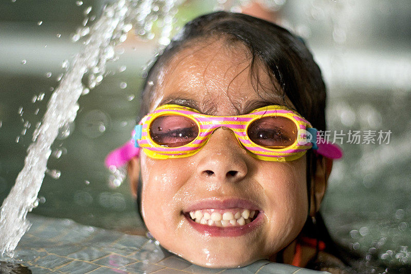 漂亮的西班牙女孩在游泳池戴着护目镜