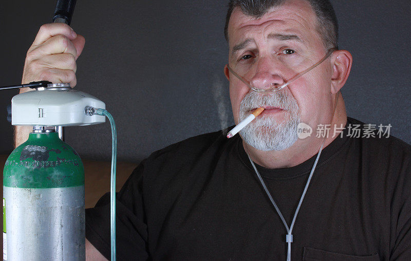 成年男子吸烟与套管和氧气罐