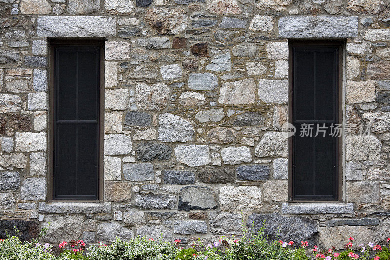 彩色的石头建筑，有两扇深色的窗户。