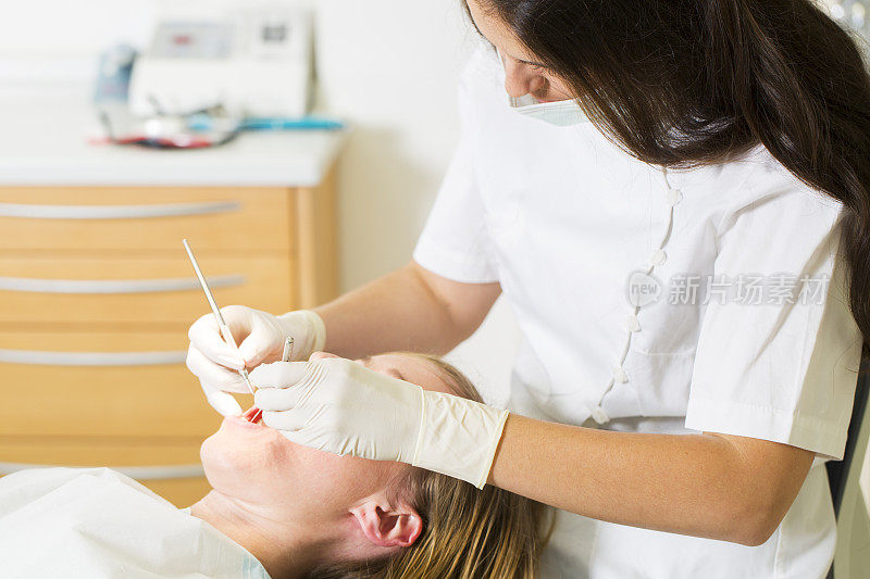 女牙医在牙医椅上与女病人一起工作