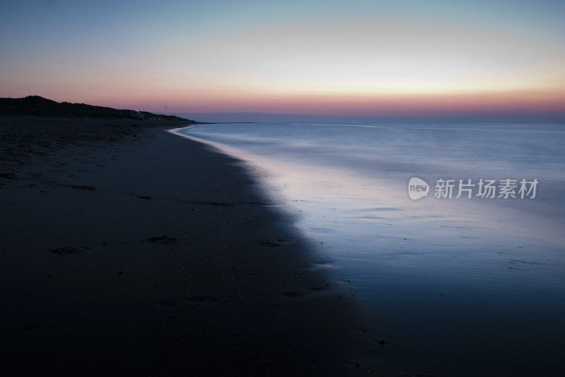 黄昏的海滩，模糊的海水和五颜六色的天空