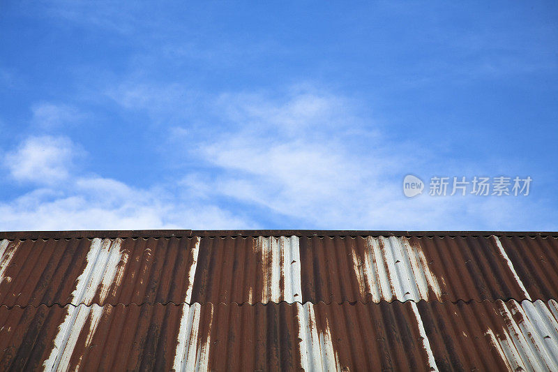 背景。生锈的铁皮屋顶和天空。