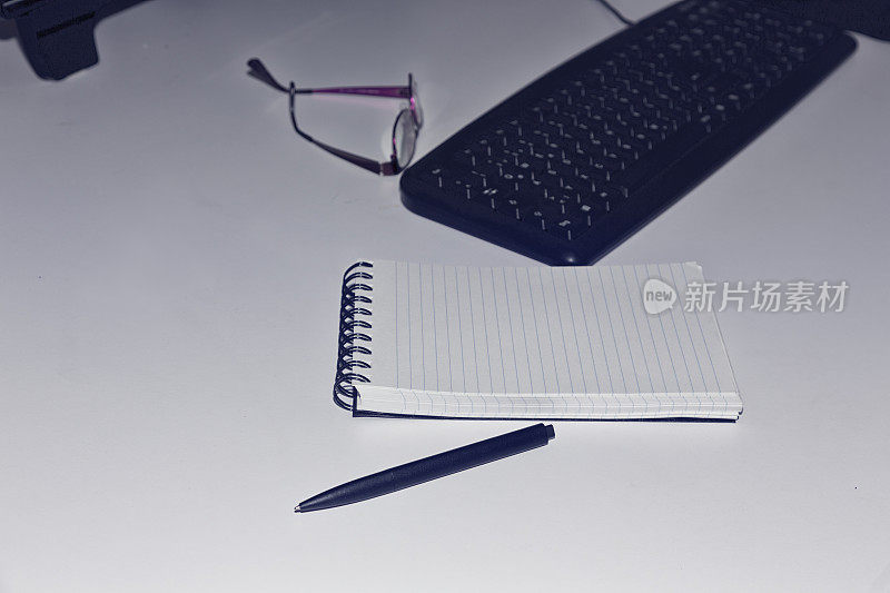 桌上有笔记本、笔和眼镜