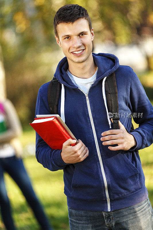 微笑大学生背包和拿书