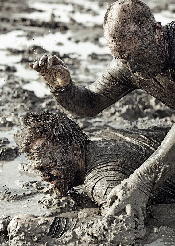 两个男人在泥里摔跤
