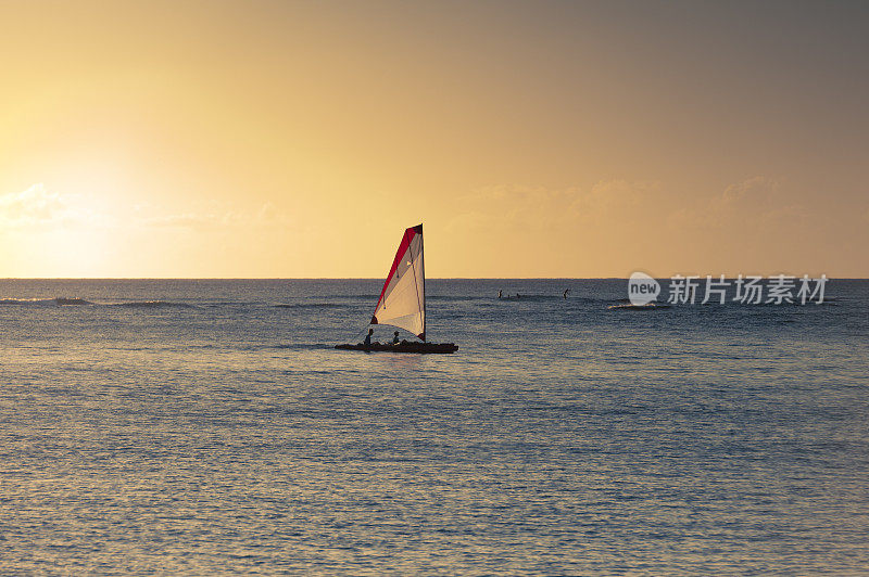夏威夷日落时帆船的剪影