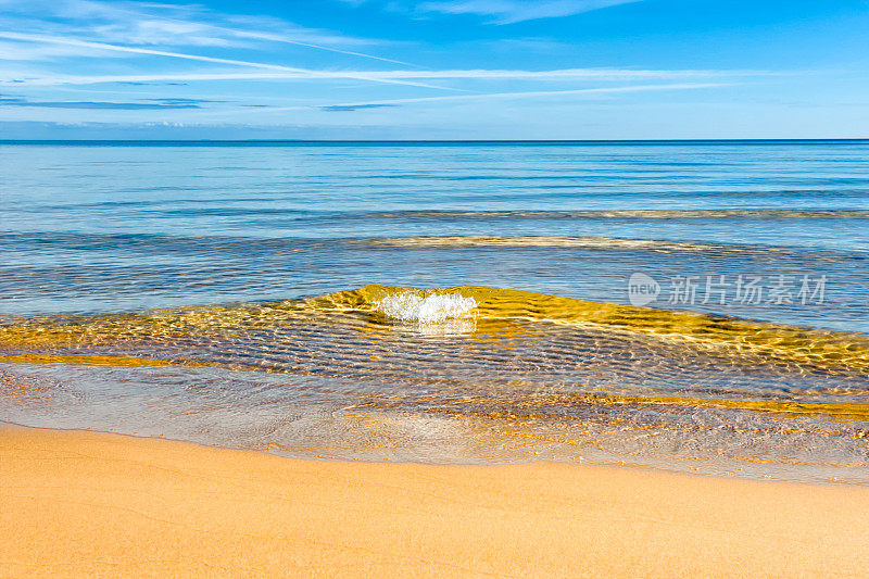 海滩波浪近距离，金色的水，蓝色的天空