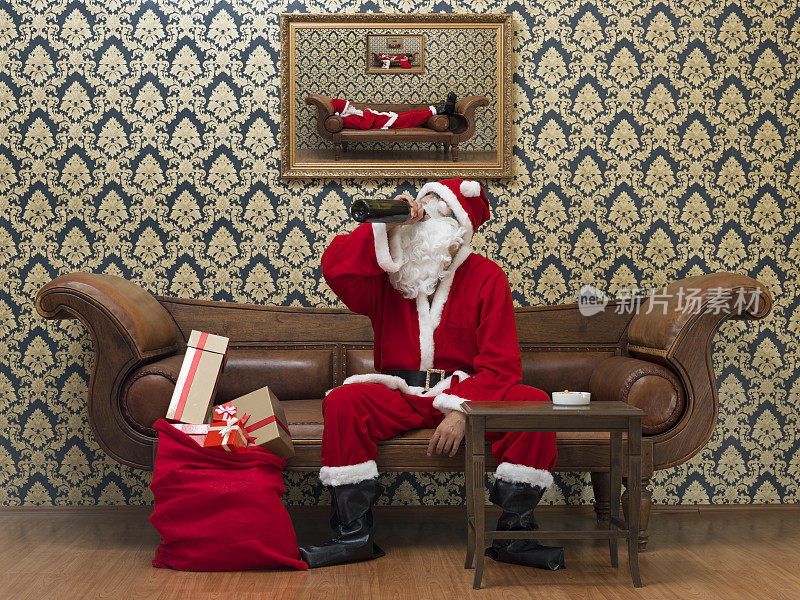 醉醺醺的圣诞老人坐在沙发上喝酒