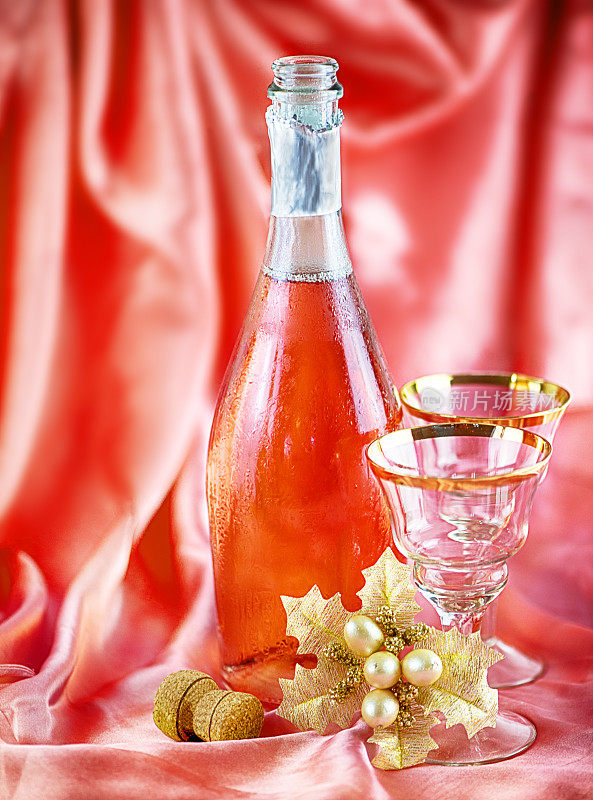 一瓶香槟和两杯红丝绸背景