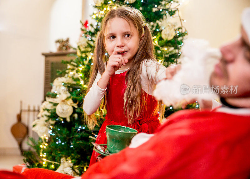 好奇的小女孩戏弄圣诞老人
