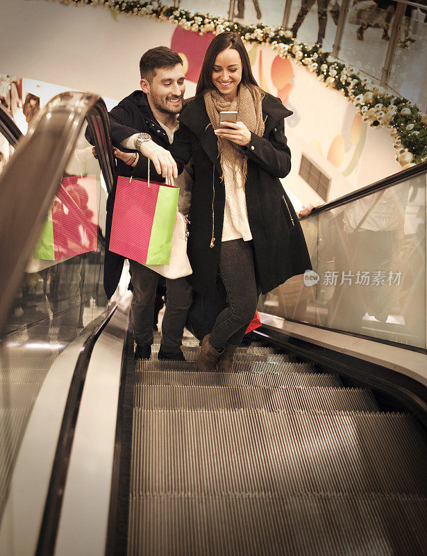购物中心电梯上微笑的情侣