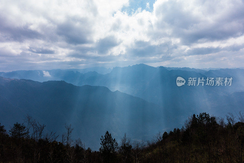 阳光透过云层在山上