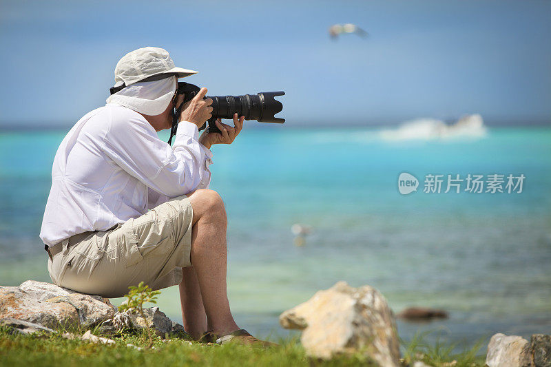 成熟的摄影师在行动与远距变焦镜头