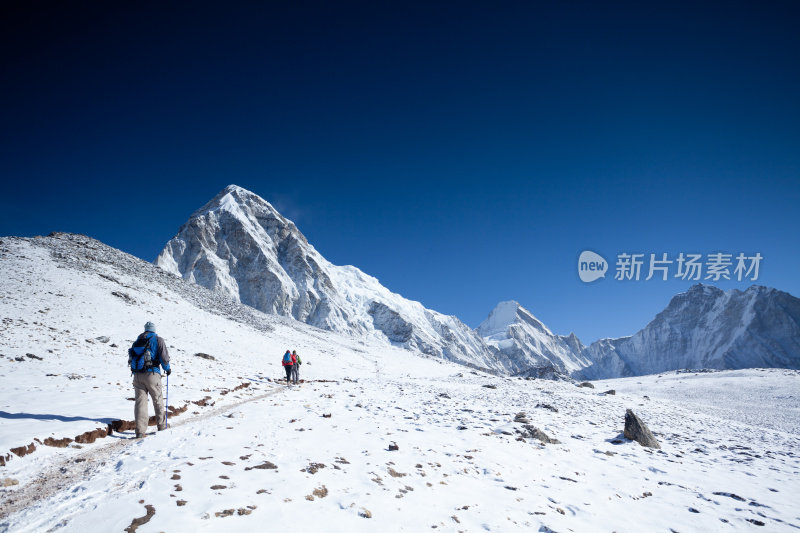 徒步旅行者穿过积雪走向希马的山峰