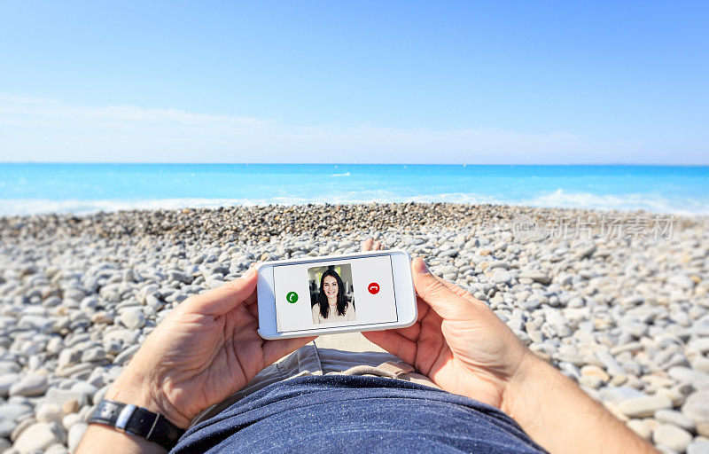 游客在海滩视频聊天与他的女朋友