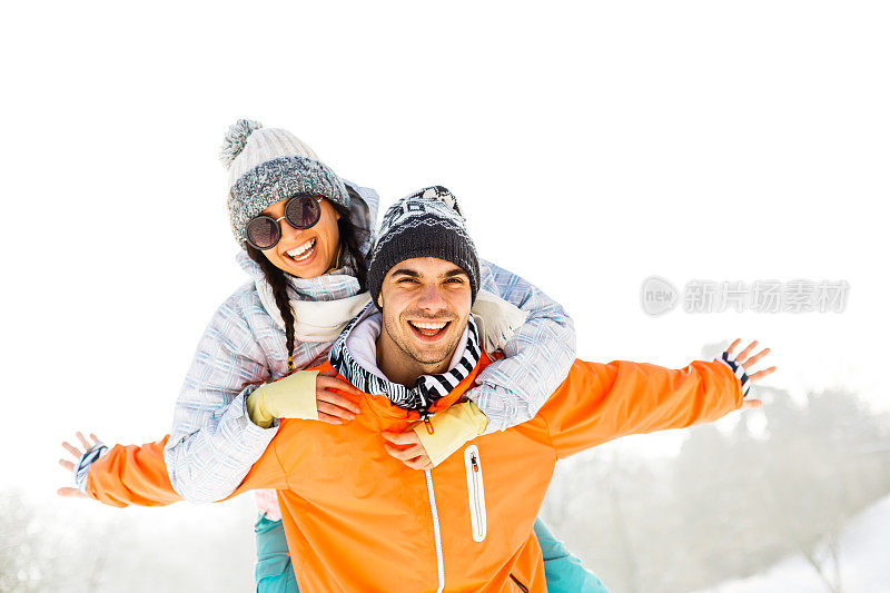 一个年轻人在寒假里背着他的女朋友