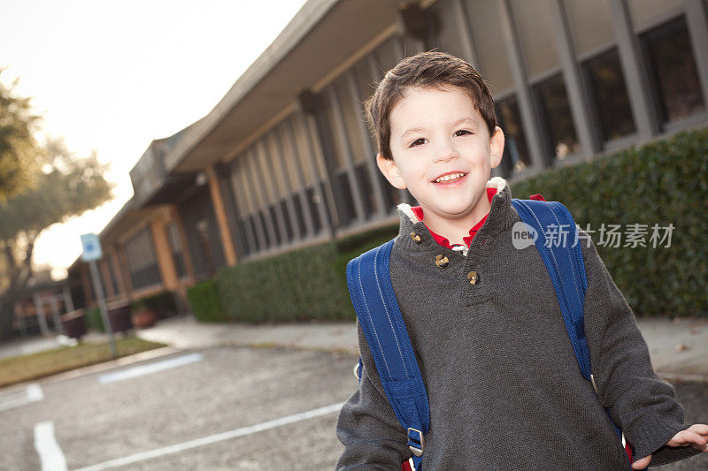 快乐的小学年龄男孩在教学楼外面