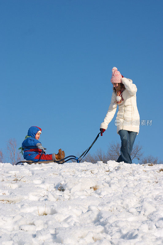 年轻的母亲，女儿和雪