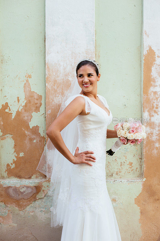 美丽的西班牙新娘站在垃圾墙旁边