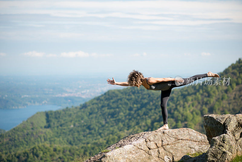 在大自然的山上练习瑜伽:战士式